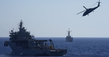 A military helicopter flies over naval ships during an annual NATO naval exercise on Türkiye’s western coast on the Mediterranean, Sept. 15, 2022. (AP Photo)