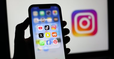 Social media applications are displayed on a mobile phone alongside the Instagram logo on a laptop screen, Liverpool, Britain, Jan. 23, 2026. (EPA Photo)