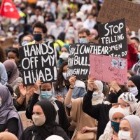 People hold placards protesting the headscarf ban at a Brussels college, Belgium, June 5, 2020. (Getty Images, File)