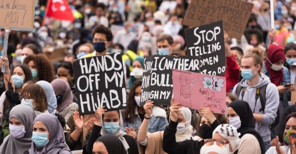 People hold placards protesting the headscarf ban at a Brussels college, Belgium, June 5, 2020. (Getty Images, File)