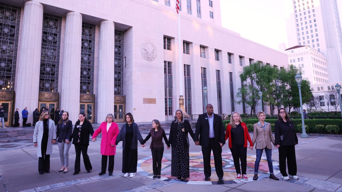 A group holds hands outside a landmark trial over whether social media platforms deliberately addict and harm children, in Los Angeles, U.S., Feb. 18, 2026. (AP Photo)