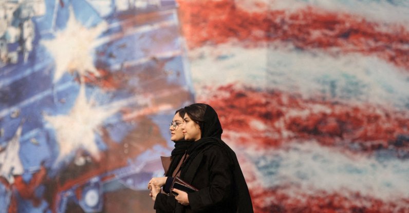 People walk past an anti-U.S. billboard in Tehran, Iran, Jan. 26, 2026. (Reuters Photo)