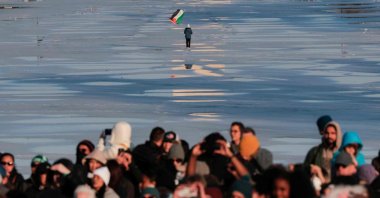 An individual carries a Palestine flag across the Reflection Pond at the Lincoln Memorial, Washington, U.S., Feb. 11, 2026. (AFP Photo)