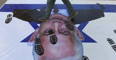 A protester steps on an Israeli flag featuring the image of Israeli Prime Minister Benjamin Netanyahu during a rally, Karachi, Pakistan, Feb. 15, 2026. (EPA Photo)