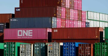 Shipping containers stand stacked while others rest on a truck transport chassis at the Port of Los Angeles, Los Angeles, U.S., Feb. 20, 2026. (AFP Photo)