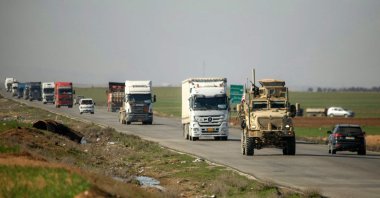 A U.S. military armored vehicle moves in a convoy with other trucks transporting military equipment along a highway outside Qamishli in Syria's northeastern Hasakah province, Syria, Feb. 23, 2026. (AFP Photo)