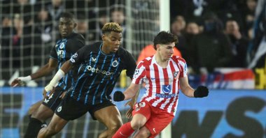 Club Brugge's Raphael Onyedika (L) and Atletico Madrid's Julian Alvarez fight for the ball during the UEFA Champions League knockout round playoff first leg football match between Club Brugge and Atletico Madrid at the Jan Breydel Stadium, Brugge, Belgium, Feb. 18, 2026. (AFP Photo)