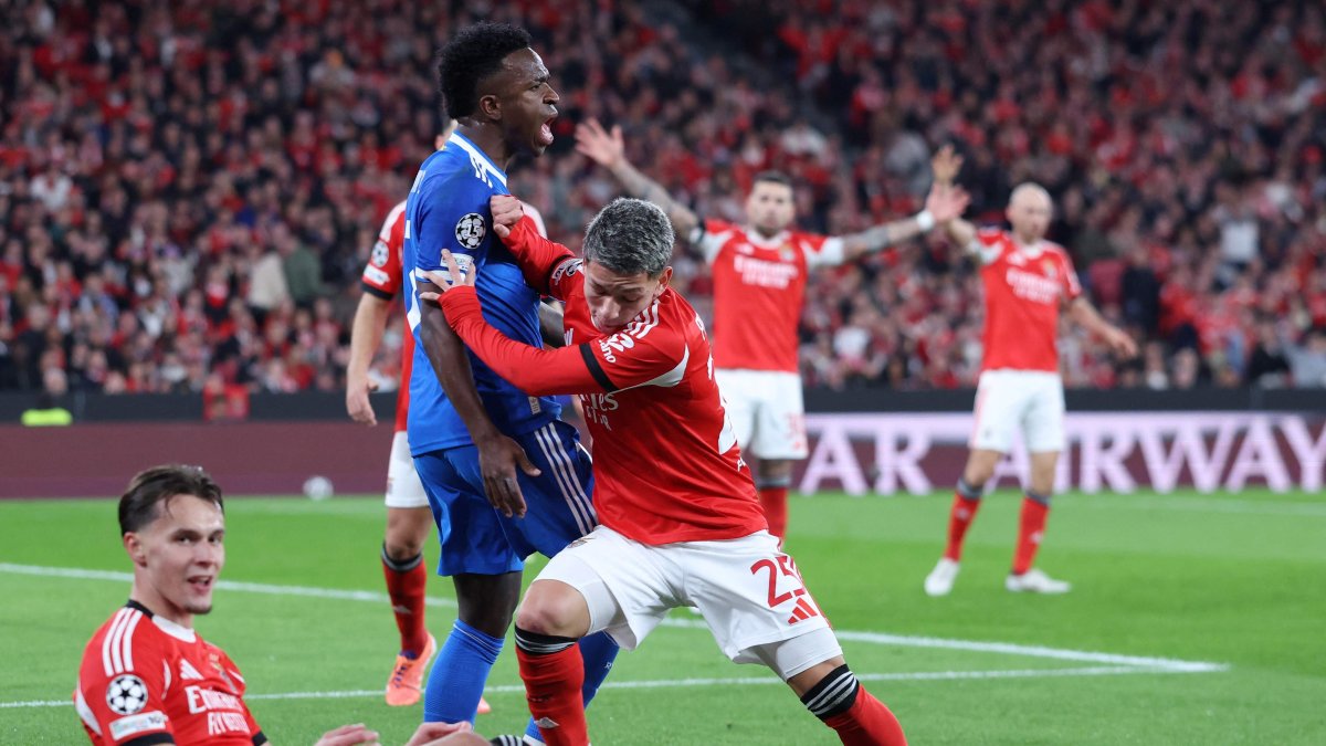 Real Madrid's Vinicius Junior (C) fights for the ball with SL Benfica's Gianluca Prestianni during the UEFA Champions League knockout round play-off first leg football match between SL Benfica and Real Madrid CF at Estadio da Luz, Lisbon, Portugal, Feb. 17, 2026. (AFP Photo)