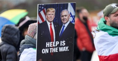 A person holds a placard with a picture of U.S. President Donald Trump alongside Israeli Prime Minister Benjamin Netanyahu (R), as protesters gather near the U.N. office, Geneva, Switzerland, Feb. 17, 2026. (Reuters Photo)