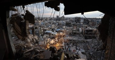 Displaced people gather for their fast-breaking iftar meal during Ramadan amid the rubble of destroyed buildings at a refugee camp, Gaza, Palestine, Feb. 23, 2026. (AFP Photo)