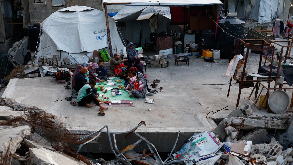 Members of the Palestinian Abu Naji family gather to break their fast by eating Iftar meals during the holy month of Ramadan, amidst the rubble of their house, which was destroyed in Israeli attacks, in Gaza City, Feb. 23, 2026. (Reuters Photo)