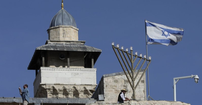 Israelis set up a large Hanukkah menorah ahead of the Jewish holiday of Hanukkah at the Ibrahimi Mosque, Hebron, Israeli-occupied West Bank, Palestine, Nov. 28, 2021. (AP Photo)
