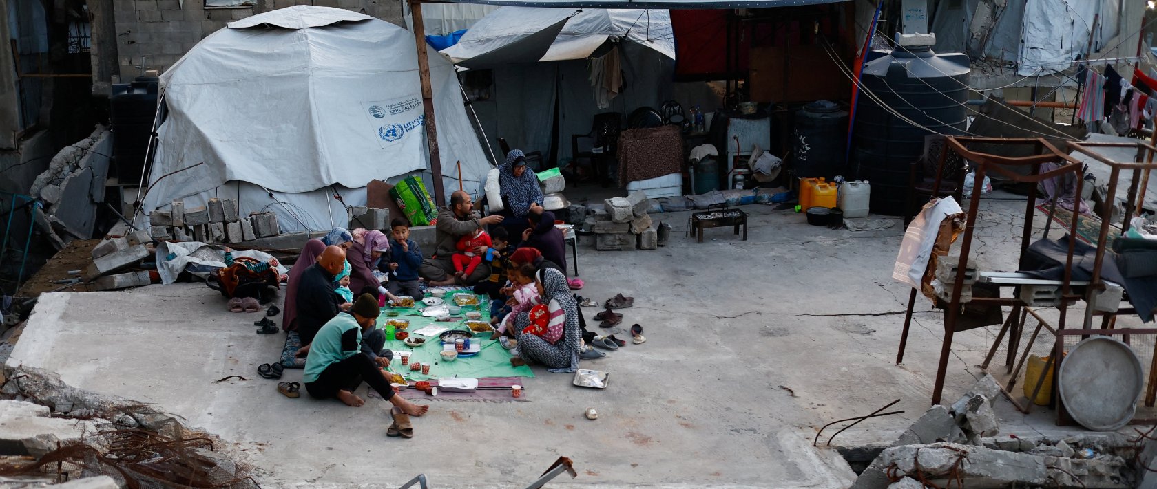 Members of the Palestinian Abu Naji family gather to break their fast by eating Iftar meals during the holy month of Ramadan, amidst the rubble of their house, which was destroyed in Israeli attacks, in Gaza City, Feb. 23, 2026. (Reuters Photo)