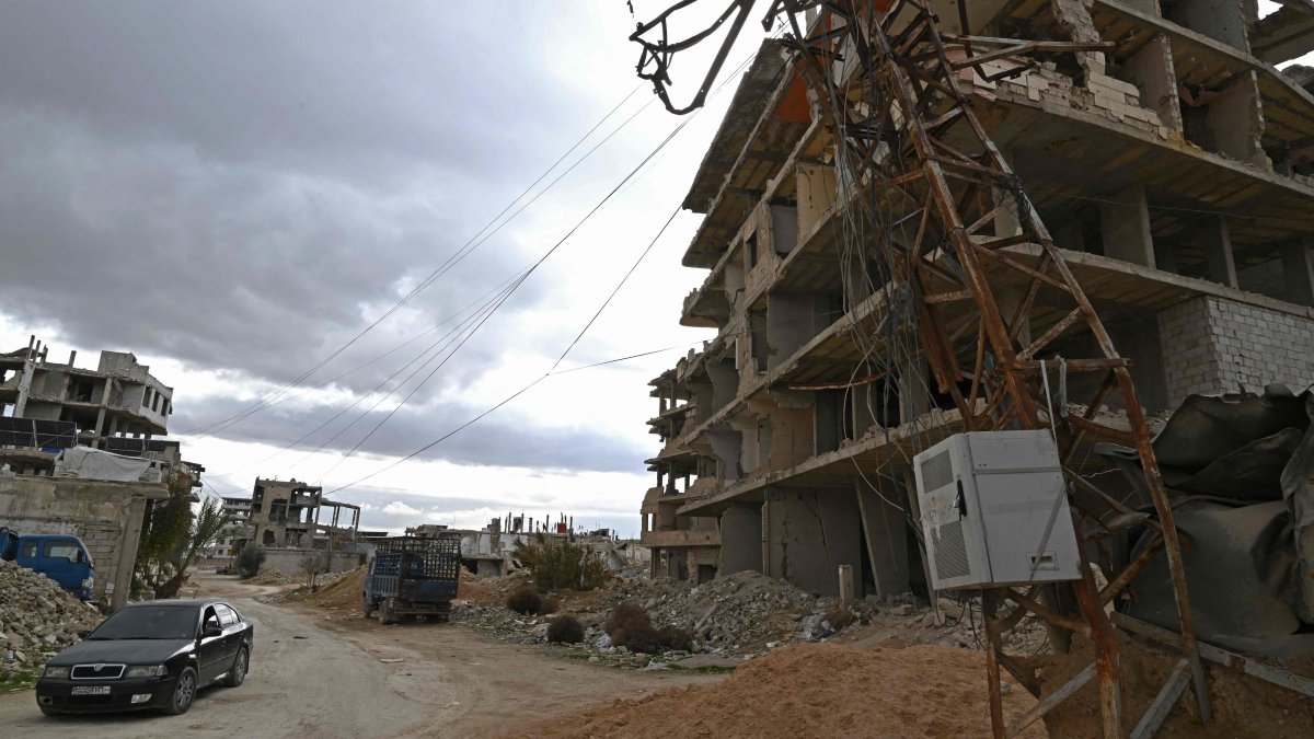A car drives past a pole tangled with overhead electric cables in the neighbourhood of Ain Tarma near Damascus, Syria, Jan. 29, 2026. (AFP Photo)