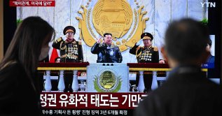 People watch a television screen showing a news broadcast with a photo of North Korea's leader Kim Jong Un attending the military parade to commemorate the 9th Congress of the Workers' Party of Korea, at a railway station, Seoul, South Korea, Feb. 26, 2026. (AFP Photo)