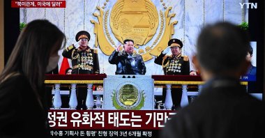 People watch a television screen showing a news broadcast with a photo of North Korea's leader Kim Jong Un attending the military parade to commemorate the 9th Congress of the Workers' Party of Korea, at a railway station, Seoul, South Korea, Feb. 26, 2026. (AFP Photo)