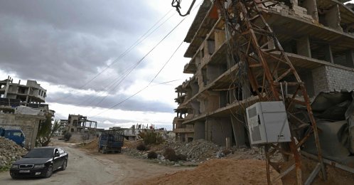 A car drives past a pole tangled with overhead electric cables in the neighbourhood of Ain Tarma near Damascus, Syria, Jan. 29, 2026. (AFP Photo)