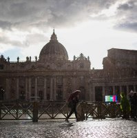 A woman holds an umbrella to shelter from the rain as she walks with St. Peter's Basilica in the background near the Vatican, Rome, Italy, April 24, 2025. (AFP Photo)