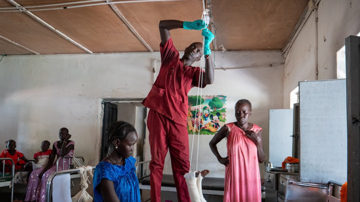 Nyayual Chuol (R) watches her 18-month-old grandson Kool Gatyen Pajock, who was shot during the conflict-hit state, receive treatment at the Akobo County Hospital, South Sudan, Feb. 21, 2026. (AP Photo)