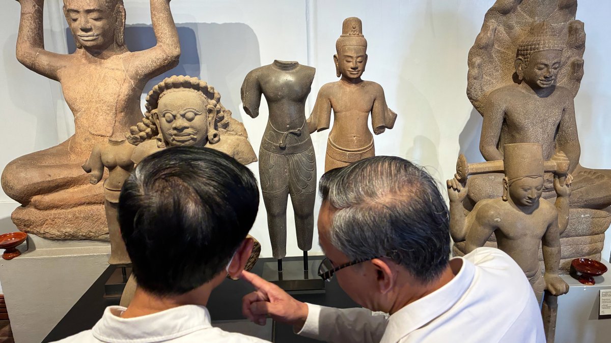 Cambodian officials look at Khmer cultural artifacts that were returned to the country, at the National Museum, Phnom Penh, Cambodia, Feb. 27, 2026. (AP Photo)