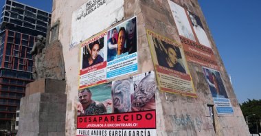 Posters bearing the faces of missing people cover the Ninos Heroes monument, Guadalajara, Mexico, Feb. 25, 2026. (AP Photo)