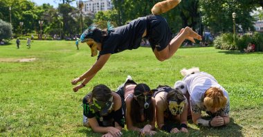 A youth jumps over other "therians," people who say they identify as non-human animals, during a gathering in a square in Buenos Aires, Argentina, Feb. 22, 2026. (AP Photo)