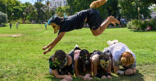 A youth jumps over other "therians," people who say they identify as non-human animals, during a gathering in a square in Buenos Aires, Argentina, Feb. 22, 2026. (AP Photo)