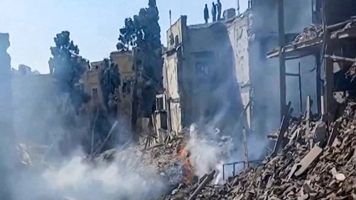 This video grab taken from UGC images posted on social media on Feb. 28, 2026 and verified by AFPTV teams in Paris shows people inspecting the damage at an impact site following U.S. and Israeli strikes on Tehran. (AFP Photo)