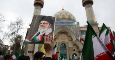 A person holds an image of Iran's Supreme Leader Ayatollah Ali Khamenei as Iranian demonstrators protest against the U.S.-Israeli strikes, in Tehran, Iran, Feb. 28, 2026. (Reuters Photo)