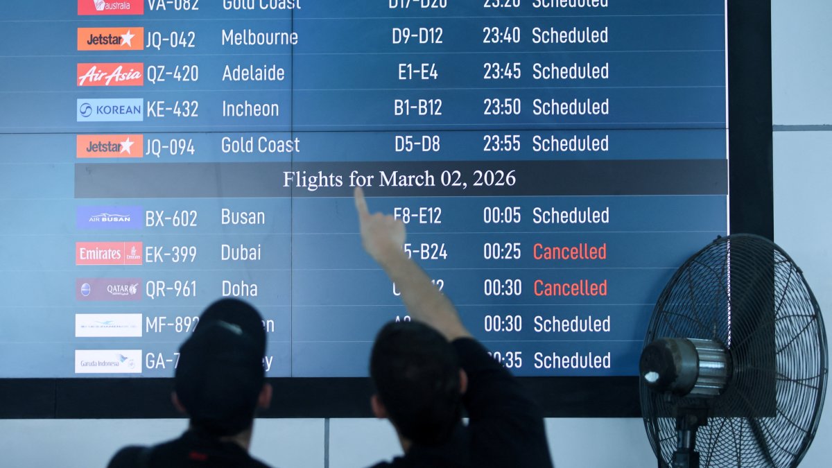 Passengers looks at departure board at I Gusti Ngurah Rai International Airport as some flights to Dubai and Doha were cancelled following strikes on Iran launched by the United States and Israel, in Kuta, Bali, Indonesia, March 1, 2026. (Reuters Photo)