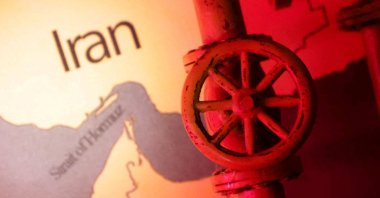 A map showing the Strait of Hormuz and Iran is seen behind a 3D printed oil pipeline in this illustration, June 22, 2025. (Reuters Photo)