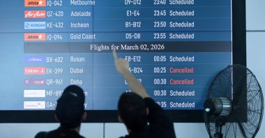 Passengers looks at departure board at I Gusti Ngurah Rai International Airport as some flights to Dubai and Doha were cancelled following strikes on Iran launched by the United States and Israel, in Kuta, Bali, Indonesia, March 1, 2026. (Reuters Photo)