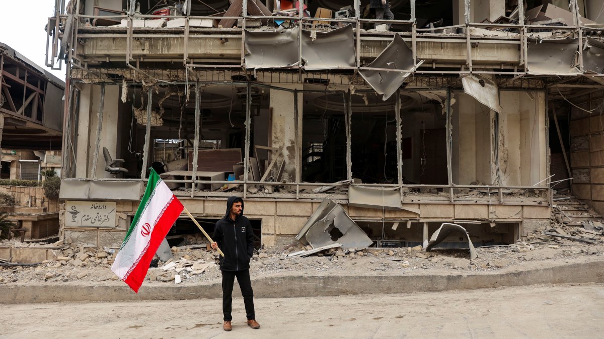 A man holds an Iranian flag following an Israeli and the U.S. strike on Gandhi Hospital, in Tehran, Iran, March 2, 2026. (Reuters Photo)