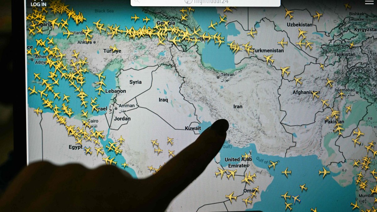 A person points at a page on the Flightradar24 website that shows civilian flights avoiding Iranian and Iraqi sky, Paris, France, March 1, 2026. (AFP Photo)