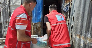 Two Turkish Red Crescent (Kızılay) volunteers distribute food packages to families in need during Ramadan, March 2, 2026. (AA Photo) 