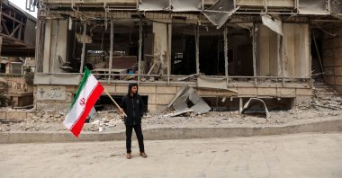 A man holds an Iranian flag following an Israeli and the U.S. strike on Gandhi Hospital, in Tehran, Iran, March 2, 2026. (Reuters Photo)