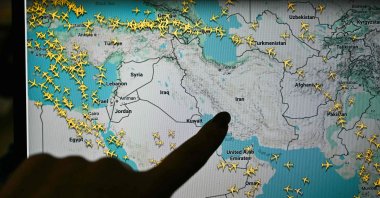 A person points at a page on the Flightradar24 website that shows civilian flights avoiding Iranian and Iraqi sky, Paris, France, March 1, 2026. (AFP Photo)