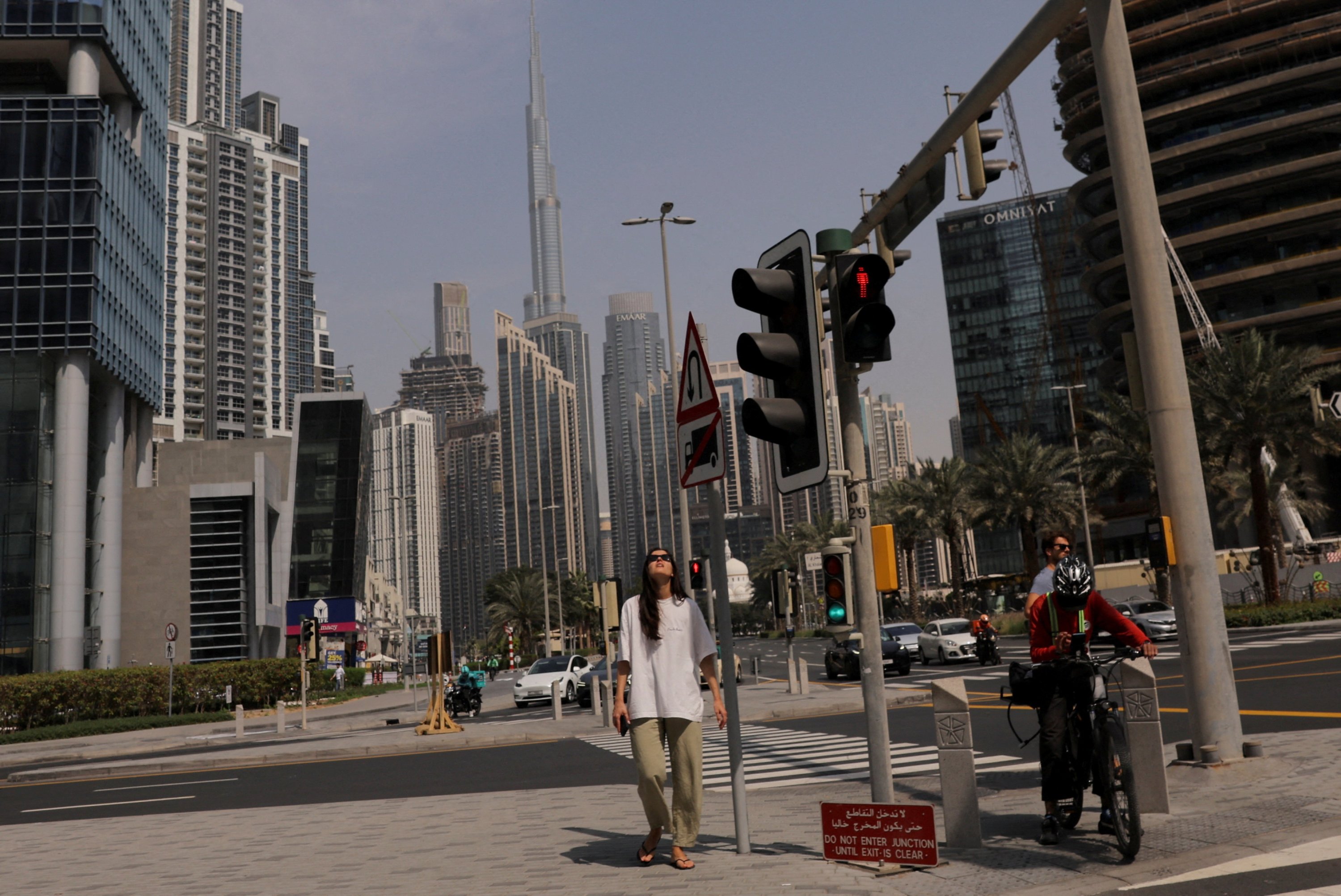 People wait at a traffic signal with the Burj Khalifa in the background, after an Iranian attack, following the U.S.-Israeli strikes on Iran, Dubai, United Arab Emirates, March 1, 2026. (Reuters Photo)
