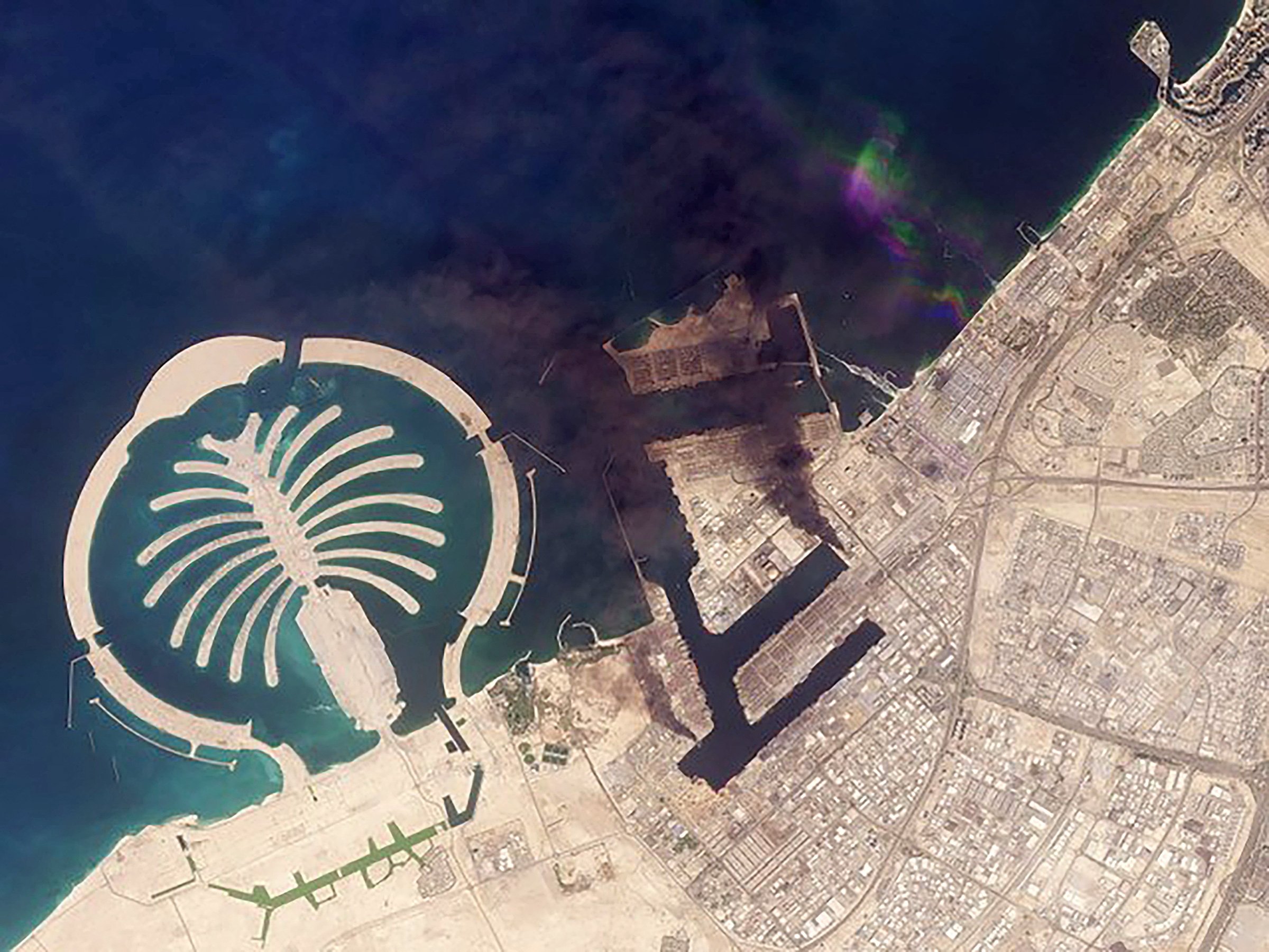 A satellite image shows smoke plumes billowing in Dubai after a projectile strike, March 2, 2026. (2026 Planet Labs PBC Handout via AFP Photo)