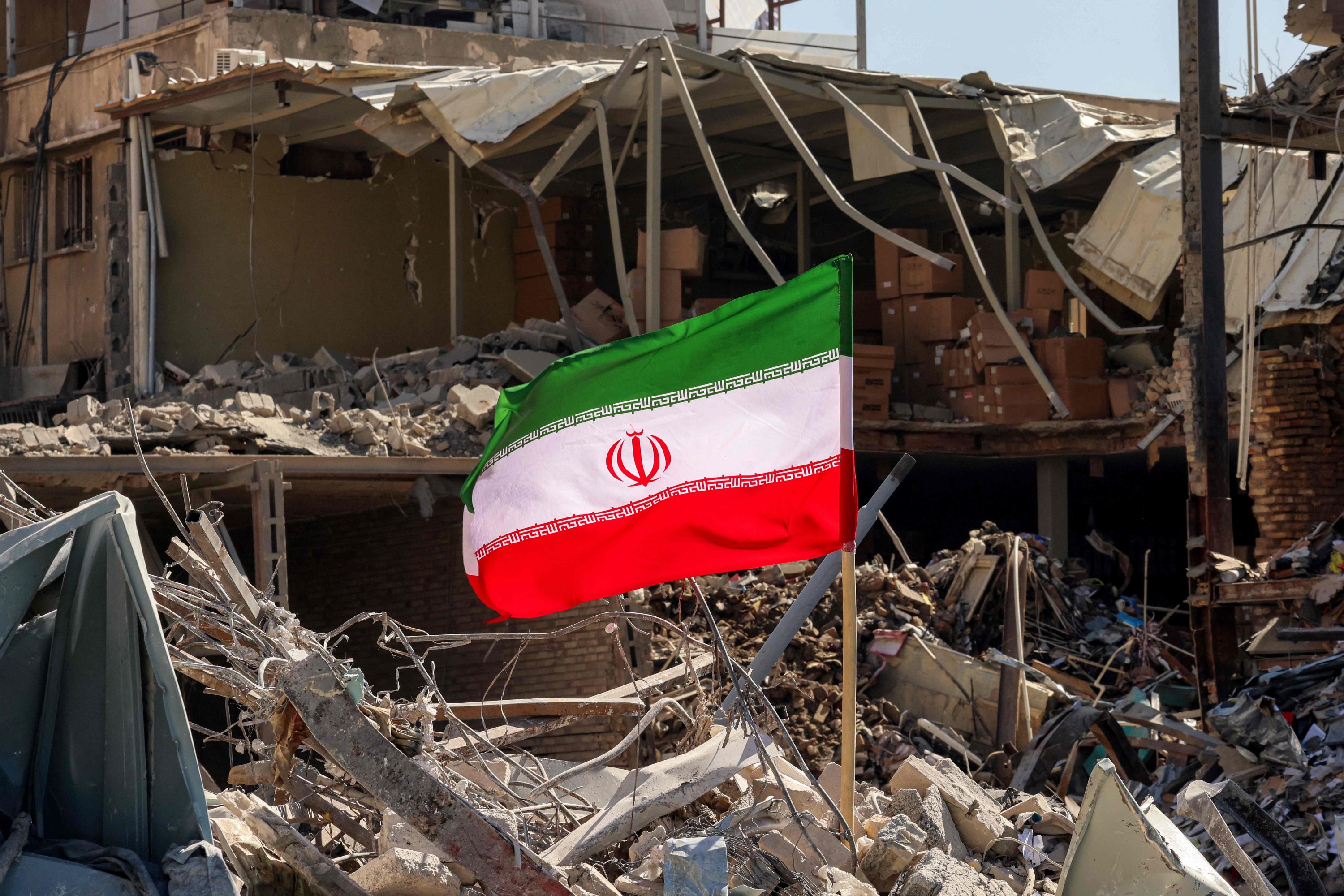 An Iranian flag is placed amidst rubble and debris of a building destroyed in U.S.-Israeli attacks near Ferdowsi Square, in Tehran, Iran, March 3, 2026. (AFP Photo)