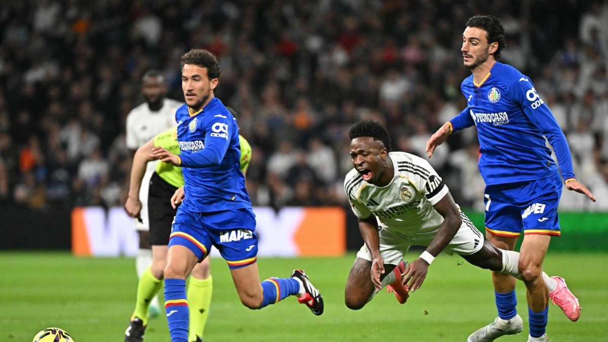 Getafe's Juan Iglesias (R) fights for the ball with Real Madrid's Vinicius Junior (C) during the Spanish league football match at Santiago Bernabeu Stadium, Madrid, Spain, March 2, 2026. (AFP Photo)