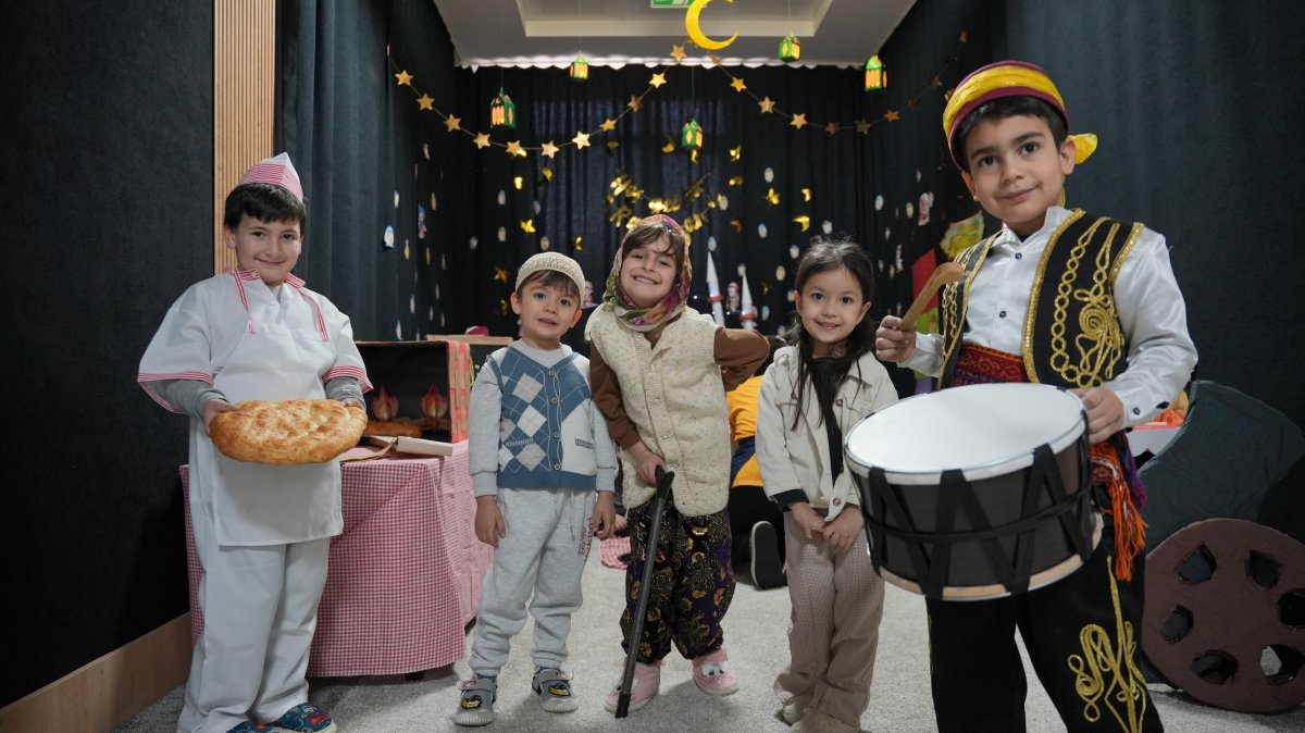 Children dressed in Ramadan-themed costumes, including a pide baker (L) and a traditional drummer, known as a “Ramazan davulcusu” (R), pose in front of Ramadan decorations at a school in Isparta, western Türkiye, Feb. 18, 2026. (AA Photo)