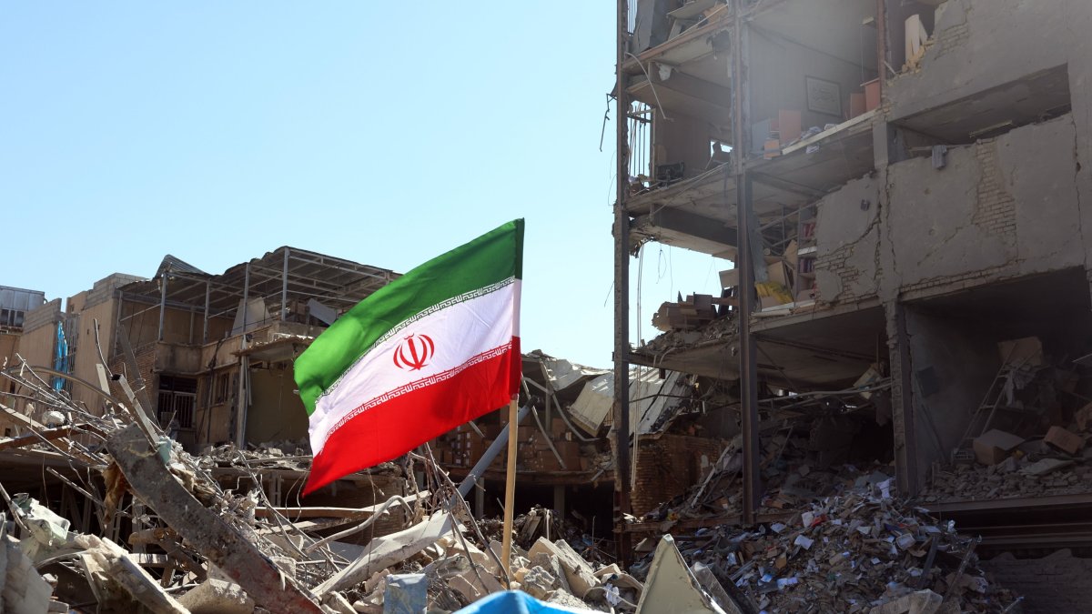 An Iranian national flag placed next to a damaged building around Ferdowsi Square after an airstrike, central Tehran, Iran, March 3, 2026. (EPA Photo)