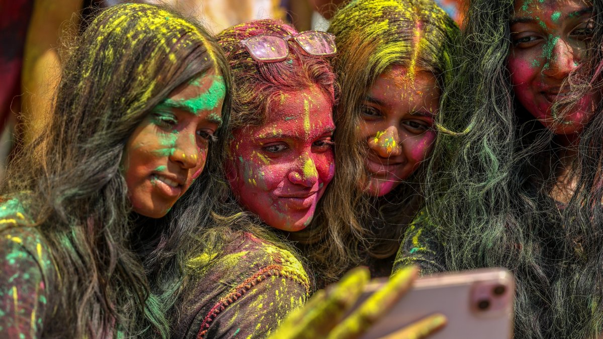 Girls with color-powder-stained faces take a selfie as they attend a Holi festival celebration, Mumbai, India, March 3, 2026. (EPA Photo)