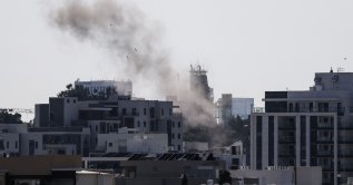 Smoke rises from behind buildings after a projectile struck the area in Tel Aviv, March 3, 2026.(AFP Photo)