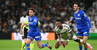Getafe's Juan Iglesias (R) fights for the ball with Real Madrid's Vinicius Junior (C) during the Spanish league football match at Santiago Bernabeu Stadium, Madrid, Spain, March 2, 2026. (AFP Photo)