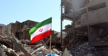 An Iranian national flag placed next to a damaged building around Ferdowsi Square after an airstrike, central Tehran, Iran, March 3, 2026. (EPA Photo)