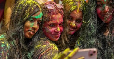 Girls with color-powder-stained faces take a selfie as they attend a Holi festival celebration, Mumbai, India, March 3, 2026. (EPA Photo)