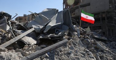 The national flag of Iran flies in the wind as debris lies scattered in the aftermath of an Israeli and U.S. strike on a police station, in Tehran, Iran, March 3, 2026. (Reuters Photo)