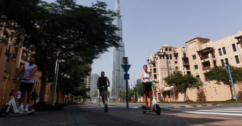 People ride scooters on a street with the Burj Khalifa in the background, after an Iranian attack, following the U.S.-Israeli strikes on Iran, Dubai, United Arab Emirates, March 1, 2026. (Reuters Photo)